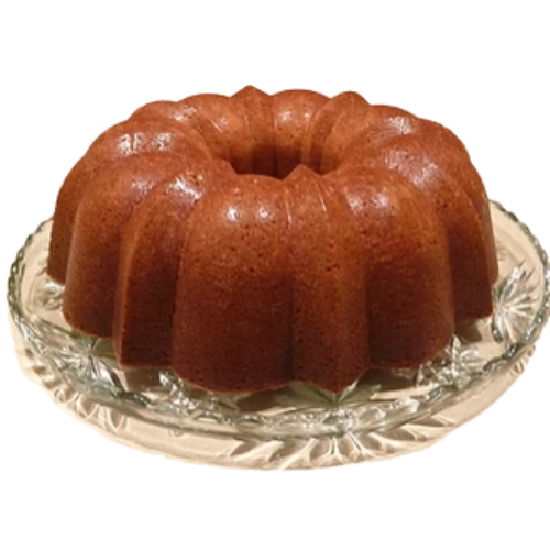 A navy bean bundt cake on a glass serving plate
